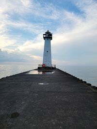 Lighthouse by sea against sky