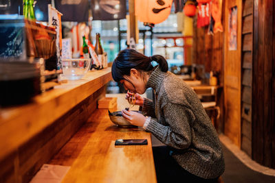 Side view of woman using mobile phone