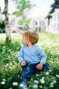 Cute boy sitting on field