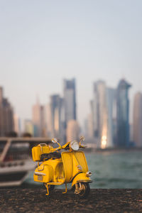 Close-up of yellow cart against buildings in city