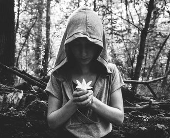 Woman holding flower at forest