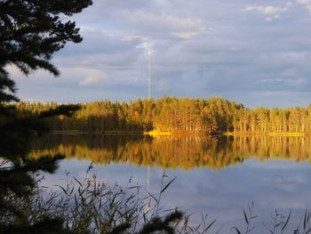 Scenic view of lake by trees against sky