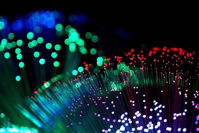 Defocused image of illuminated lights against black background