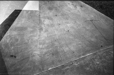 High angle view of arrow sign on tiled floor