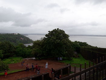 People by sea against sky