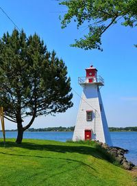 Lighthouse by trees against sky on charlottetown in canada