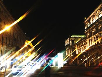 Light trails on road in city against sky at night