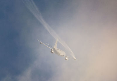 Low angle view of airplane flying against sky