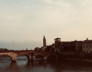 Bridge over river against buildings in city