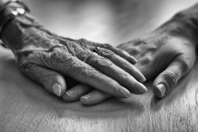 Cropped hands of senior man and woman on table