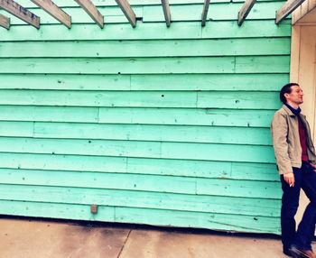 Portrait of man leaning against wall