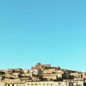 Low angle view of buildings against clear blue sky