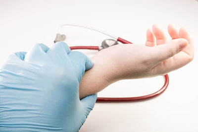 Close-up of hands holding camera over white background