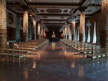 Empty chairs and tables in illuminated building