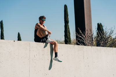 Side view of man riding motorcycle against clear sky