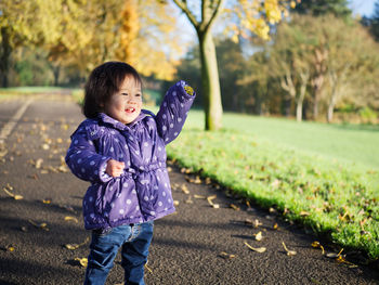 Cute baby girl standing on pathway at park
