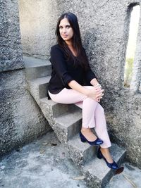 Portrait of young woman sitting on steps