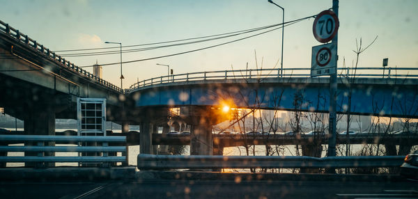 Bridge over city against sky during sunset