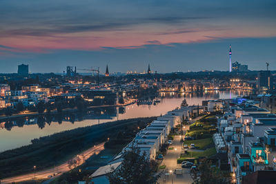 High angle view of illuminated buildings against sky at dusk