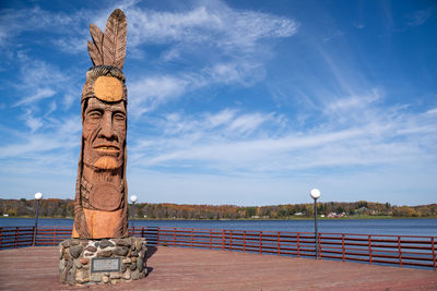 Statue by sea against sky