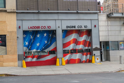 Multi colored flags hanging on street against buildings in city