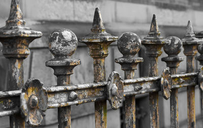 Close-up of rusty metal chain against fence