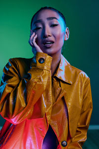 Portrait of young woman against black background