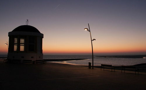 Silhouette beach against sky during sunset