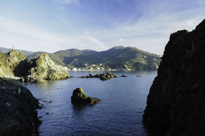 Scenic view of sea and mountains against sky