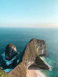 Scenic view of cliff and sea against blue sky