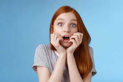 Scared woman against blue background