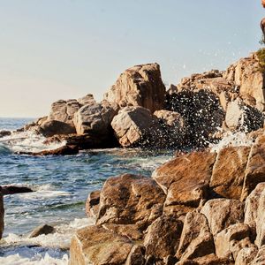 Rocks on beach against clear sky