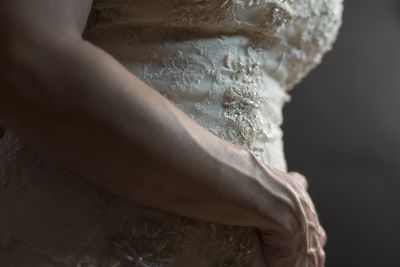 Midsection of woman in white dress