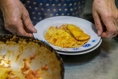 Midsection of man preparing food in plate