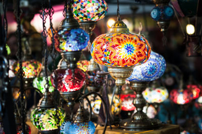 Illuminated lanterns hanging in store for sale