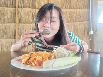 Portrait of woman holding ice cream in restaurant