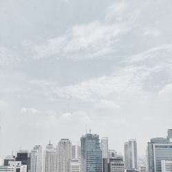Low angle view of modern buildings against cloudy sky