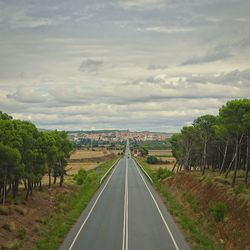 Road amidst trees against sky