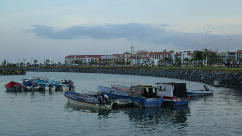 Boats in river with city in background