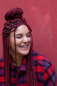 Portrait of young woman standing against wall