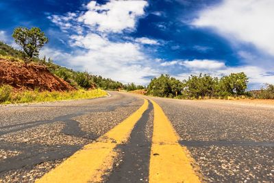 Road by trees against sky