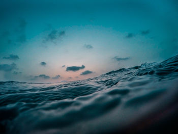 Water surface level of sea against sky at sunset