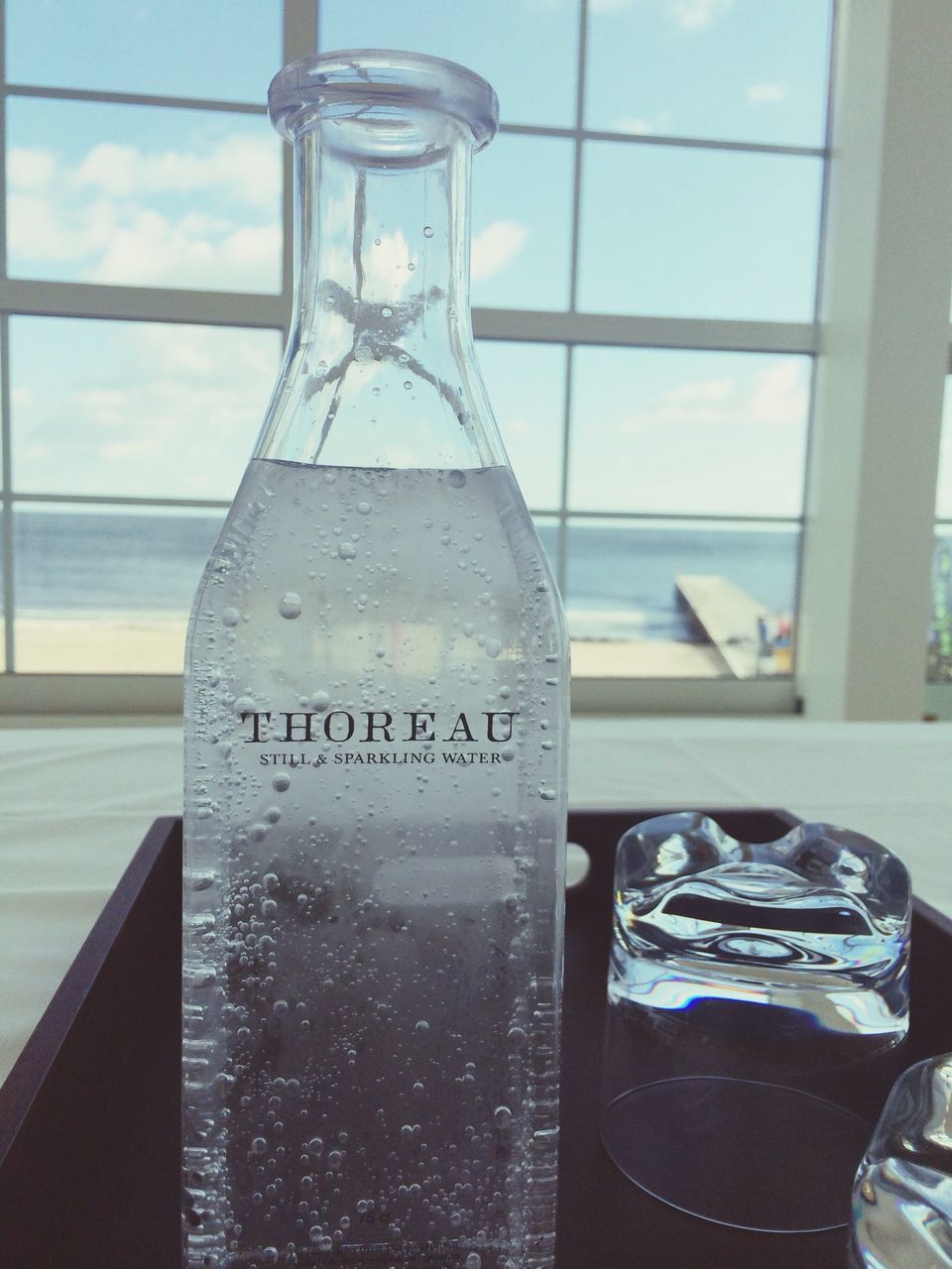 indoors, glass - material, transparent, window, glass, still life, food and drink, table, drinking glass, drink, close-up, text, refreshment, no people, reflection, western script, day, jar, bottle, water