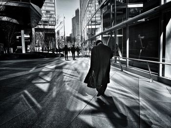 Rear view of man walking on city street