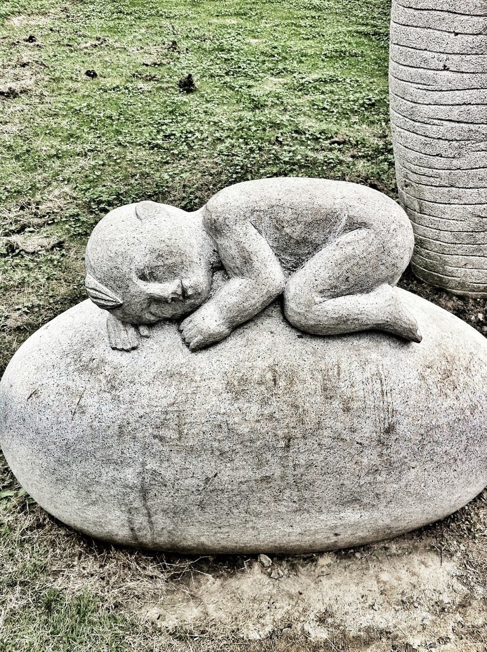 sculpture, art, human representation, art and craft, statue, creativity, animal representation, outdoors, day, carving - craft product, no people, stone, high angle view, stone material, wall - building feature, close-up, grass, stone - object, animal themes