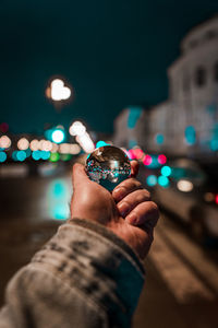 Ma holding sphere in city