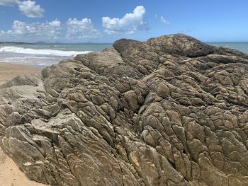 Scenic view of rocks on beach against sky