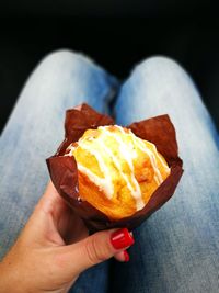 Low section of woman holding muffin