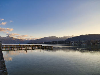 Pier over lake against sky during sunset