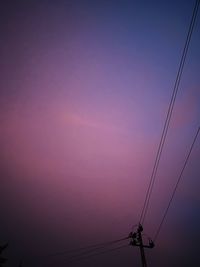 Low angle view of electricity pylon against romantic sky